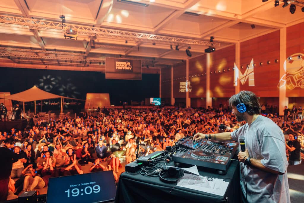 DJ und große Menge mit leuchtenden Silent Disco Kopfhörern